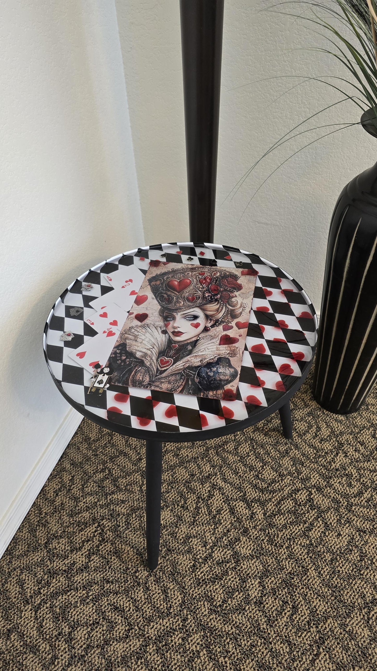 Round Queen of Hearts inspired end table with black and white checker background, preserved in crystal clear resin.