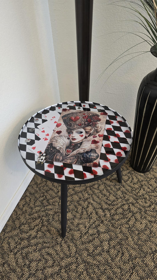Round Queen of Hearts inspired end table with black and white checker background, preserved in crystal clear resin.