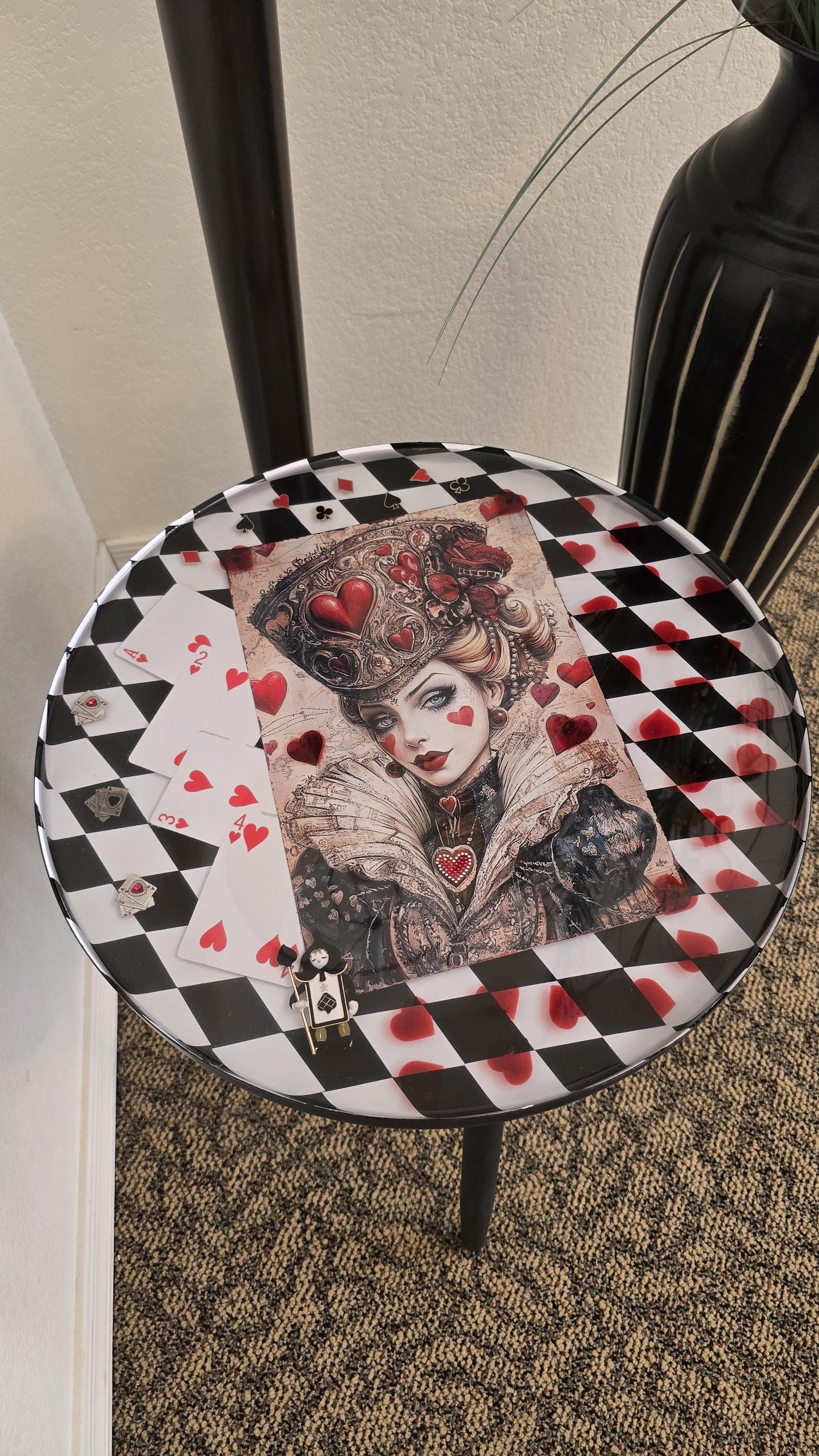 Round Queen of Hearts inspired end table with black and white checker background, preserved in crystal clear resin.